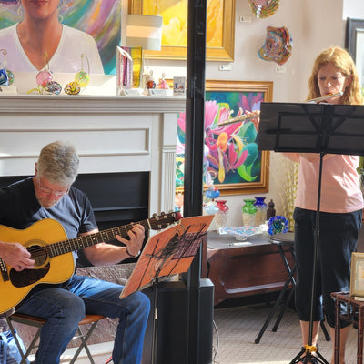 Two people in a room with musical instruments and sheet music.